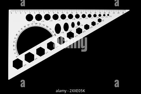 Science et éducation - règle triangulaire multifonctionnelle règle-pochoir pour dessin géométrique isolé sur fond noir. Le travailleur des chemins est p. Banque D'Images