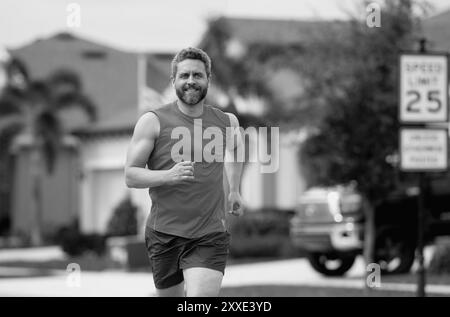 Beau homme d'âge moyen traversant le quartier américain. Homme sportif en plein air. Un mode de vie sain. Jogging actif et sain en extérieur. Banque D'Images