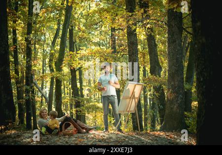 Peinture dans la nature. Démarrer une nouvelle photo. Capturez l'instant. Beauté de la nature. Homme barbu femme et fils mignon relaxant nature automnale. Dessiner de la vie Banque D'Images