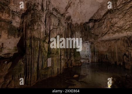 Vue intérieure de la grotte de Neptune en Sardaigne, Italie, avec de superbes stalactites et formations de stalagmites. L'eau sur le sol de la grotte se reflète Banque D'Images