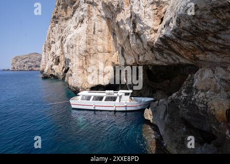 Alghero, Italie - 25 août 2023 : bateau entrant dans la grotte de Neptune (Grotta di Nettuno) sur l'île de Sardaigne pour ramasser les touristes après le GUID Banque D'Images