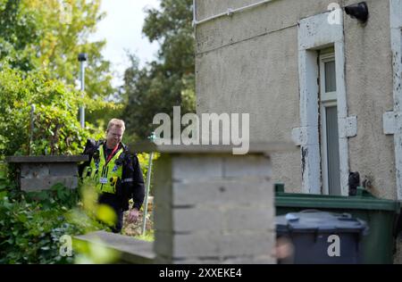 La police devant une maison à Carlby Grove, alors que la police du West Yorkshire a déclaré qu'un certain nombre de mandats avaient été exécutés dans la zone Keighley de Bradford pendant la nuit en relation avec l'incendie mortel du 21 août. Deux autres personnes ont été arrêtées sur suspicion de meurtre suite à l'incendie de la maison qui a tué une mère et trois enfants à Bradford. Date de la photo : samedi 24 août 2024. Banque D'Images