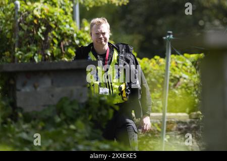 La police devant une maison à Carlby Grove, alors que la police du West Yorkshire a déclaré qu'un certain nombre de mandats avaient été exécutés dans la zone Keighley de Bradford pendant la nuit en relation avec l'incendie mortel du 21 août. Deux autres personnes ont été arrêtées sur suspicion de meurtre suite à l'incendie de la maison qui a tué une mère et trois enfants à Bradford. Date de la photo : samedi 24 août 2024. Banque D'Images