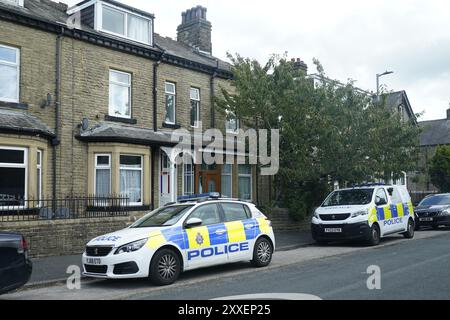 La police devant une maison à Malsis Road, alors que la police du West Yorkshire a déclaré qu'un certain nombre de mandats avaient été exécutés dans la zone Keighley de Bradford pendant la nuit en relation avec l'incendie mortel du 21 août. Deux autres personnes ont été arrêtées sur suspicion de meurtre suite à l'incendie de la maison qui a tué une mère et trois enfants à Bradford. Date de la photo : samedi 24 août 2024. Banque D'Images