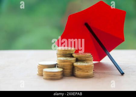 Parapluie recouvrant les pièces d'or représentant la protection et la sécurité. Concept de sécurité et d'assurance. Banque D'Images