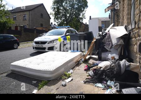 La police devant une maison dans Minnie Street, alors que la police du West Yorkshire a déclaré qu'un certain nombre de mandats avaient été exécutés dans la zone Keighley de Bradford pendant la nuit en relation avec l'incendie mortel du 21 août. Deux autres personnes ont été arrêtées sur suspicion de meurtre suite à l'incendie de la maison qui a tué une mère et trois enfants à Bradford. Date de la photo : samedi 24 août 2024. Banque D'Images