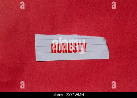 Message d'honnêteté écrit sur un morceau de papier déchiré déchiré avec un fond rouge. Symbole d'honnêteté conceptuel. Copier l'espace. Banque D'Images