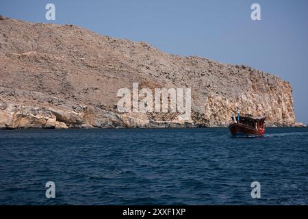 Dhows arabes traditionnels avec des touristes naviguant dans les eaux ressemblant à un fjord de la péninsule de Musandam, Oman Banque D'Images