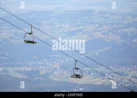 Téléphérique des gens dans les montagnes sur le fond de la ville dans la vallée de montagne Banque D'Images