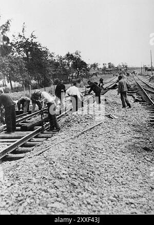 Prisonniers de travail forcé du camp de concentration de Buchenwald construisant la ligne de chemin de fer Weimar-Buchenwald. Buchenwald et ses 139 sous-camps étaient des camps de travaux forcés et non des camps de la mort et il n'y avait pas de chambres à gaz. Cependant, les mauvaises conditions, les abus et les exécutions ont entraîné la mort de 56500 personnes dans ce pays. Il a été libéré par l'armée américaine le 11 avril 1945. La photo est datée du 16 avril 1945, cinq jours après la libération du camp par l'armée américaine. Banque D'Images