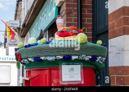Topper de boîte aux lettres en tricot ou en crochet avec signe fabriqué par Bagshot WI (Womens Institute, Inspiring Women), arts et artisanat, Surrey, Angleterre, ROYAUME-UNI Banque D'Images