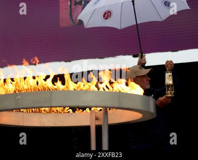 Stoke Mandeville, Britain. 24th Aug, 2024. Officials light a flame lantern from the cauldron during the Paralympic Torch-Lighting Ceremony for the Paris 2024 Paralympic Games at Stoke Mandeville, Britain, on August 24, 2024. Credit: Li Ying/Xinhua/Alamy Live News Stock Photo