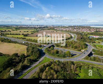 Trafic sur l'autoroute M56 à la jonction 14, Helsby avec la raffinerie de pétrole Stanlow en arrière-plan, Cheshire, Angleterre Banque D'Images