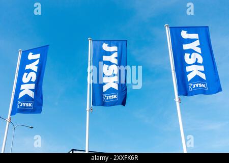 Signez JYSK logo drapeaux contre le ciel bleu Banque D'Images