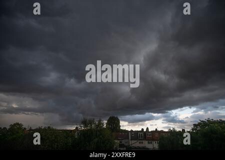 Wimbledon, Londres, Royaume-Uni. 24 août 2024. Après une journée ou de la pluie en début de soirée, des nuages de tonnerre sombres traversent Londres avec la fissure occasionnelle du tonnerre. Crédit : Malcolm Park/Alamy Live News Banque D'Images