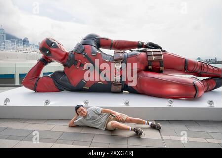 Hong Kong, Chine. 18 août 2024. Un visiteur se fait prendre en photo alors qu'il pose avec l'installation de 8 mètres du personnage de Marvel Deadpool, mis en place pour promouvoir le nouveau film 'Deadpool & Wolverine' sorti sous Disney à Hong Kong. (Crédit image : © Miguel Candela/SOPA images via ZUMA Press Wire) USAGE ÉDITORIAL SEULEMENT! Non destiné à UN USAGE commercial ! Banque D'Images