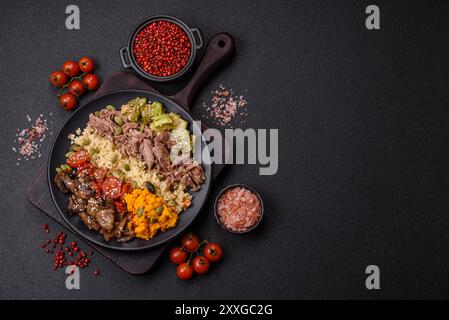 Bol de nourriture avec boeuf, bulgur, tomates, champignons, courgettes et sauce. Plat végétalien Banque D'Images