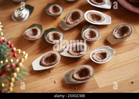 Préparation de biscuits de Noël faits maison sous forme de noix - pâte crue pressée dans des moules en étain Banque D'Images