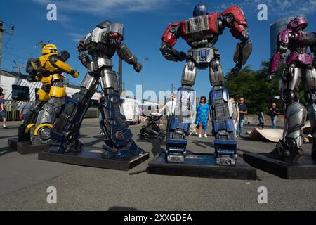 Cologne, Allemagne. 24 août 2024. Les touristes prennent des photos avec l'installation pour promouvoir le prochain film ''Transformers One'' de l'autre côté du Rhin de la cathédrale Dom à Cologne, en Allemagne, le 24 août 2024. (Photo de Ying Tang/NurPhoto) crédit : NurPhoto SRL/Alamy Live News Banque D'Images