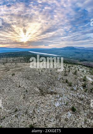 Coucher de soleil sur le vaste paysage vu du sommet de la montagne Hemmeråsen, révélant les collines ondulantes et le lac Burusjön au loin, Idre Dalarna Suède Banque D'Images