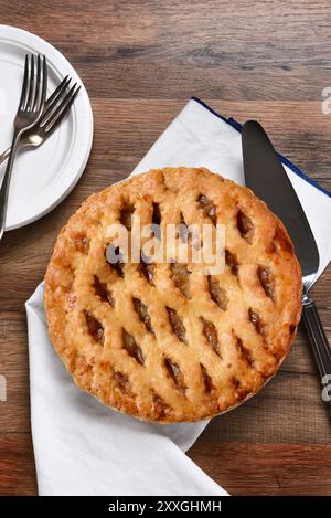 Une tarte aux pommes fraîchement cuite, serveur avec assiettes et fourchettes. Le dessert fait partie d'un festin typique de Thanksgiving. Banque D'Images