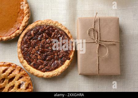 Trois tartes des fêtes, noix de pécan, citrouille et pomme avec emballage emballé. Banque D'Images