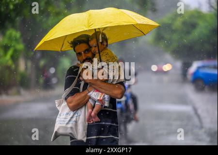 New Delhi, Inde. 24 août 2024. NOIDA, INDE - 23 AOÛT : les navetteurs sortent sous la pluie dans le secteur 12, le 23 août 2024 à Noida, Inde. (Photo de Sunil Ghosh/Hindustan Times/Sipa USA ) crédit : Sipa USA/Alamy Live News Banque D'Images