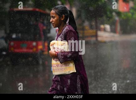New Delhi, Inde. 24 août 2024. NOIDA, INDE - 23 AOÛT : les navetteurs sortent sous la pluie dans le secteur 12, le 23 août 2024 à Noida, Inde. (Photo de Sunil Ghosh/Hindustan Times/Sipa USA ) crédit : Sipa USA/Alamy Live News Banque D'Images