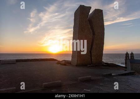 Coucher de soleil sur la côte de Muxia dans le nord-ouest espagnol. La sculpture A Ferida (la blessure), l'une des plus grandes œuvres d'art en Espagne, rappelle l'un des plus grands accidents maritimes en Espagne, quand en 2002 un pétrolier a causé une marée noire massive. Des milliers de bénévoles sont venus dans la ville pour aider à nettoyer les dégâts. Banque D'Images