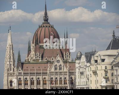 Bâtiment néogothique du parlement avec dôme et tours, devant un ciel bleu avec des nuages blancs, budapest, danube, hongrie Banque D'Images