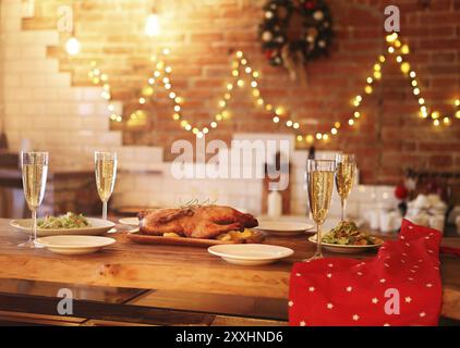 Le dîner de Noël avec du canard rôti et champagne sur table en bois Banque D'Images