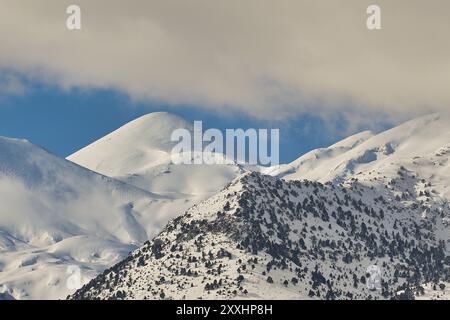 Sommets de montagne enneigés silhouettés contre un ciel bleu clair avec quelques nuages, Lefka Ori, montagnes blanches, massif montagneux, ouest, Crète, Grèce, Banque D'Images