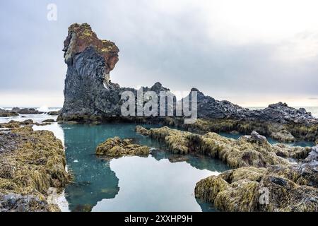 Belles formations rocheuses au bord de la mer à la plage de Djupalonssandur sur la péninsule de Snaefellsnes en hiver en Islande Banque D'Images