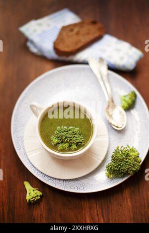 Au-dessus d'une soupe saine et savoureuse à la crème de brocoli servie dans un mug en céramique blanche sur une table en bois avec pain grillé Banque D'Images