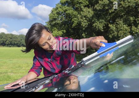 Nettoyage du pare-brise de voiture femme colombienne dans la nature Banque D'Images