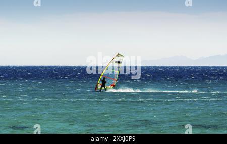 Planche à voile sur fond de montagnes balade sur les vagues de la mer Rouge en Egypte Dahab Banque D'Images