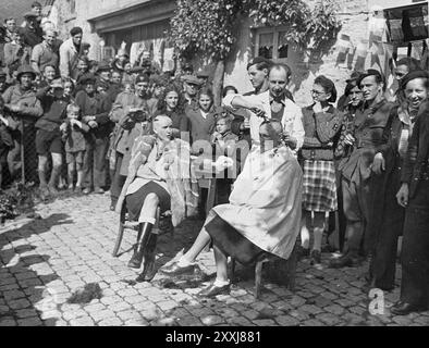 Des femmes soupçonnées d'avoir collaboré avec les Allemands punis à Lanaken en Belgique. Les membres de la résistance rasent les cheveux de la femme et peignent des swastikas sur leurs têtes avant de les faire défiler dans les rues. La photo est datée du 15 septembre 1944 Banque D'Images