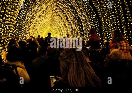 Les gens à l'intérieur de la cathédrale de la lumière, les enfants élevés sur les épaules dans un tunnel d'installation d'art de lumières de fées pour VIVID Sydney 2016 Banque D'Images