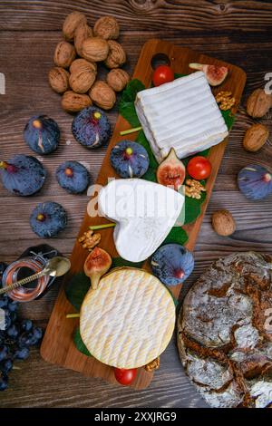 Sélection de fromages français de Normandie, AOP, Livarot, Neufchatel, Pont l'eveque, pain de seigle, figues, noix, raisins, gelée de sureau Banque D'Images