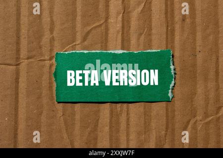 Message de version bêta écrit sur un morceau de papier vert déchiré avec fond de carton. Symbole de version bêta conceptuelle. Copier l'espace. Banque D'Images