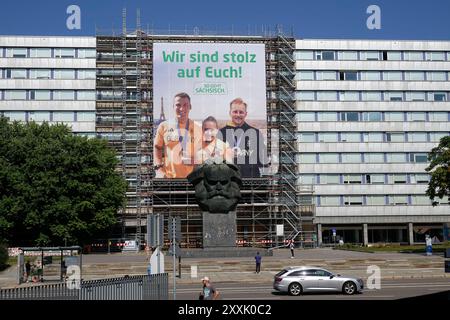 Sächsische Olympiamedaillengewinner Plakat 24.08.2024, Chemnitz, Brückenstraße, Karl-Marx-Monument, Chemnitz 23. Août 2024 Bronze, Silber, Gold die sportlichen Ausnahmeleistungen der drei sächsischen Olympiagevainqueur Rebekka Haase, Luca Witzke und Tom Liebscher-Lucz erfahren seit heute 23. Août 2024 durch die Kampagne ÂSo geht Sächsisch. â eine aufmerksamkeitsstarke und weithin sichtbare Würdigung. Auf einem überdimensional großen Fassadenbanner von 18x20 Metern in der Chemnitzer Innenstadt, direkt hinter dem markanten ÂNischlÂ, prangt in riesigen Lettern ÂWir sind stolz auf EuchÂ. Darunter Banque D'Images