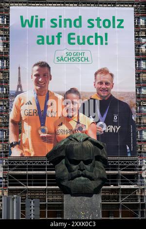 Sächsische Olympiamedaillengewinner Plakat 24.08.2024, Chemnitz, Brückenstraße, Karl-Marx-Monument, Chemnitz 23. Août 2024 Bronze, Silber, Gold die sportlichen Ausnahmeleistungen der drei sächsischen Olympiagevainqueur Rebekka Haase, Luca Witzke und Tom Liebscher-Lucz erfahren seit heute 23. Août 2024 durch die Kampagne ÂSo geht Sächsisch. â eine aufmerksamkeitsstarke und weithin sichtbare Würdigung. Auf einem überdimensional großen Fassadenbanner von 18x20 Metern in der Chemnitzer Innenstadt, direkt hinter dem markanten ÂNischlÂ, prangt in riesigen Lettern ÂWir sind stolz auf EuchÂ. Darunter Banque D'Images