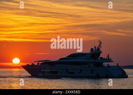 Un superyacht en mer en Croatie alors que le soleil se couche au crépuscule un soir d'été Banque D'Images