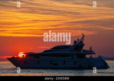 Un superyacht en mer en Croatie alors que le soleil se couche au crépuscule un soir d'été Banque D'Images