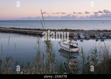 Le petit port du village de pêcheurs de Marinella di Selinunte dans l'ouest de la Sicile au coucher du soleil Banque D'Images