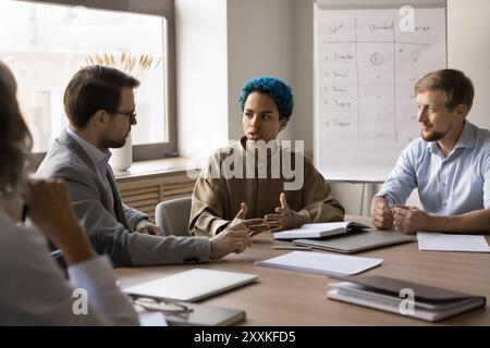 Groupe de jeunes professionnels multiraciaux réunis autour d'une table de conférence Banque D'Images