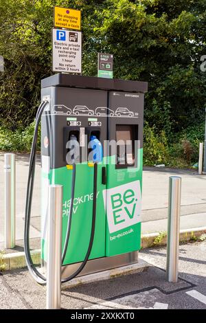 Salford, Greater Manchester, Royaume-Uni. 24 août 2024 : borne de recharge moderne de véhicules électriques dans une aire de stationnement avec des instructions et une signalisation claires. Banque D'Images