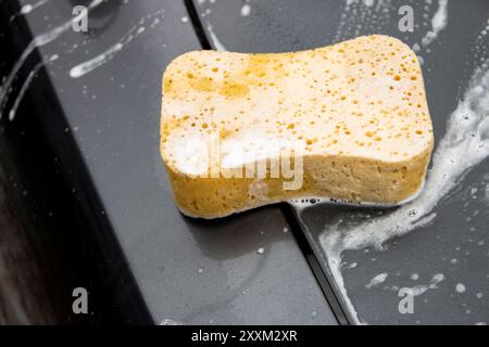 Lavage de voitures. Nettoyage d'automobile avec de la mousse. Véhicule recouvert de détergents chimiques à base de shampooing mousse pendant le libre-service du lave-auto Banque D'Images