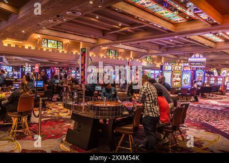 Les touristes et les Américains à l'intérieur du casino à Las Vegas, une capitale de jeu des États-Unis, avec le poker, les tables de roulette, et les machines à sous Banque D'Images