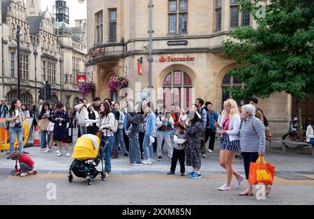 Touristes chinois visiteurs dans un groupe de touristes debout sur Queen Street à l'extérieur de Santander Bank dans Oxford City Centre Oxfordshire Angleterre Royaume-Uni KATHY DEWITT Banque D'Images